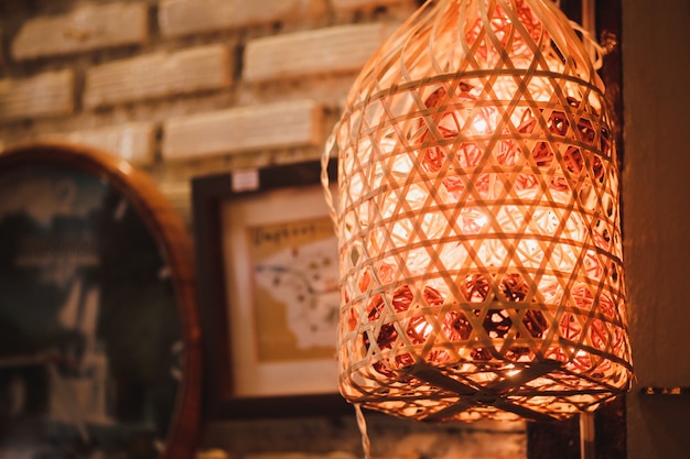 Colorful cotton ball light bulbs hanging in the basket on the wall with bokeh background.