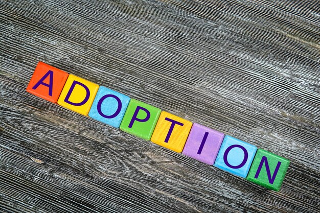 나무 배경에 Word ADOPTION이 있는 다채로운 큐브