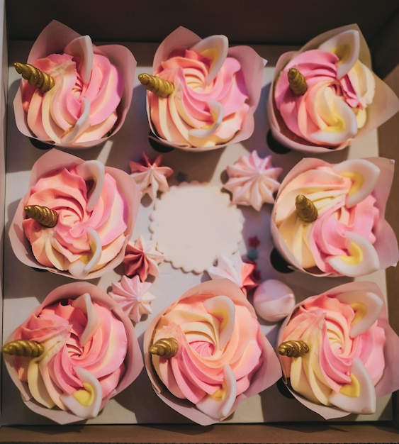 Foto dessert di cupcakes colorati con corna e orecchie d'oro di unicorno per il compleanno, festa di addio al nubilato per ragazze, regalo di umorismo dolce e divertente