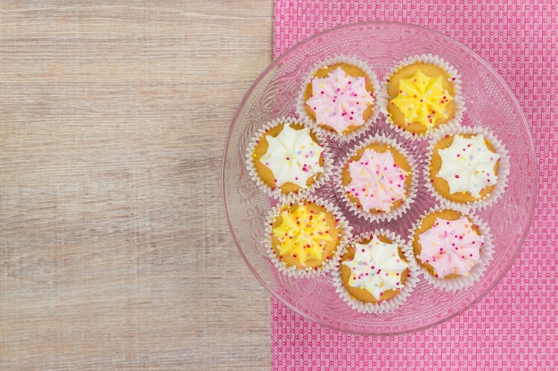 Colorful cupcakes on a white wood background. Top view with space for your text.