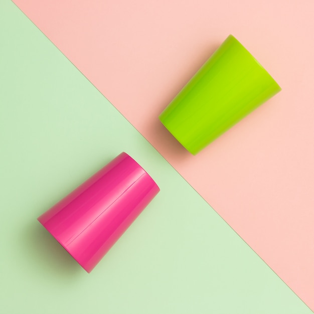 Colorful cups on different pastel backgrounds.