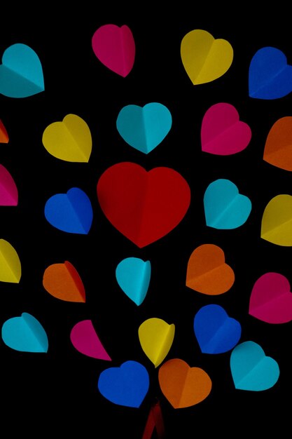 colorful cut out paper hearts on a black smooth background