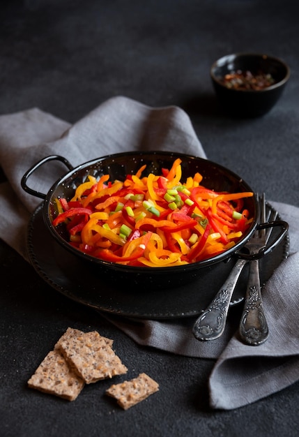 Colorful cut peppers in a black bowl