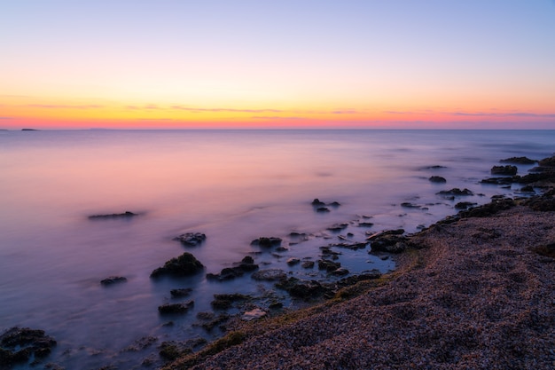 Красочный рассвет на каменистом берегу моря, фотосъемка с длительной выдержкой