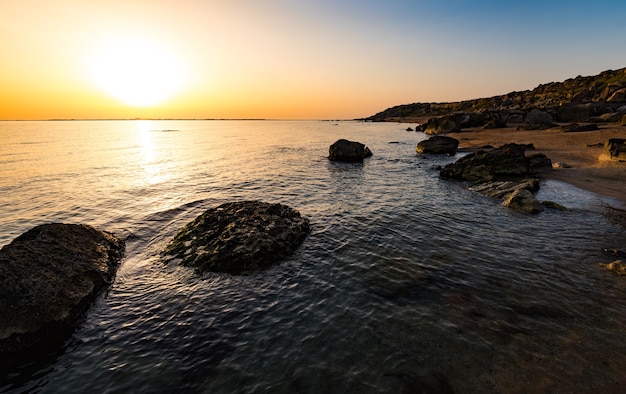 Alba colorata in riva al mare