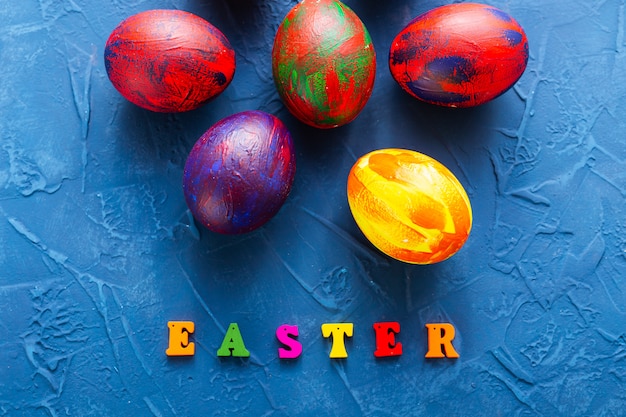 Colorful decorative eggs and letters on a blue background