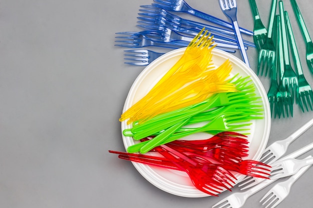 白いプレート上のカラフルな使い捨てプラスチックフォーク