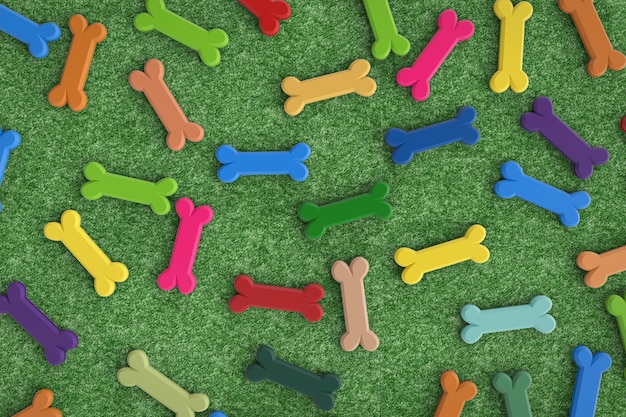 Colorful dog bones on green turf background