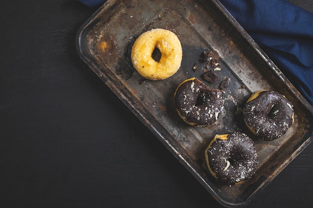 Colorful donuts on Black table. Top view