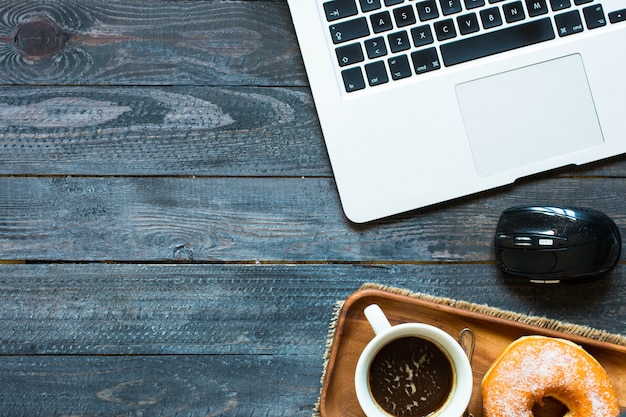 Colorful Donuts breakfast composition with laptop and coffee mug