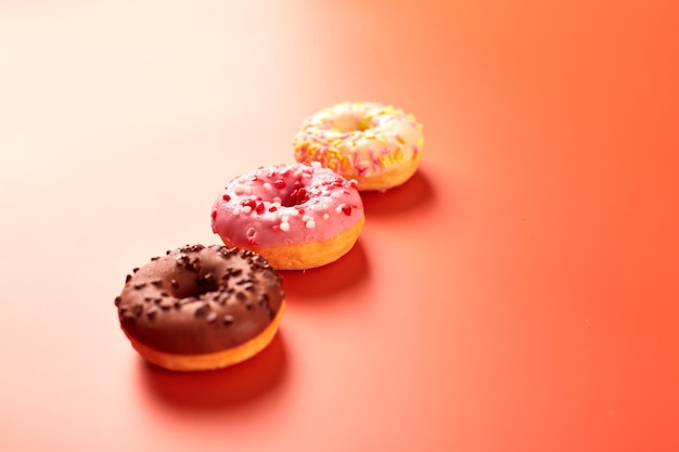 Colorful donuts on purple background Copy space