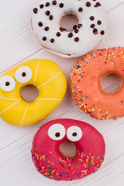 Colorful donuts on wooden background.