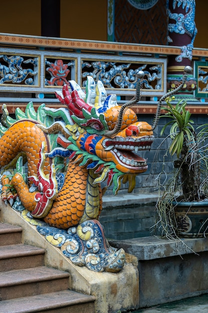 Colorful dragon sculpture at the entrance to a Buddhist temple on the steps in the city of Danang