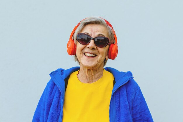 사진 긍정적인 태도와 선글라스를 쓴 멋진 행복한 미소를 지닌 화려한 옷을 입은 노인 여성 시민