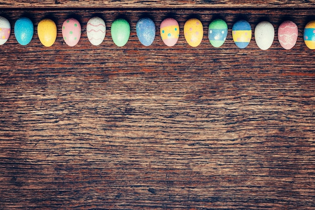 Colorful easter egg on wood background with space. Vintage toned.