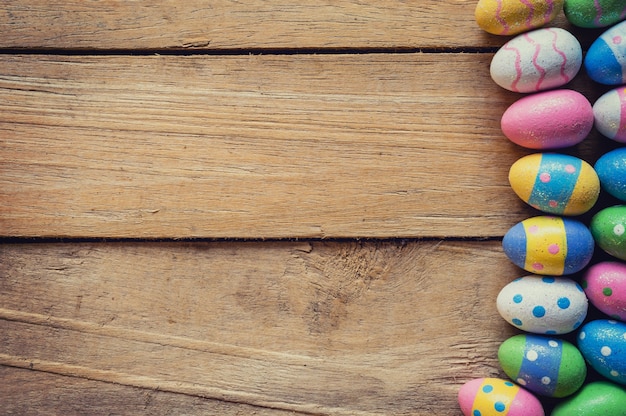 Colorful easter egg on wood background with space.