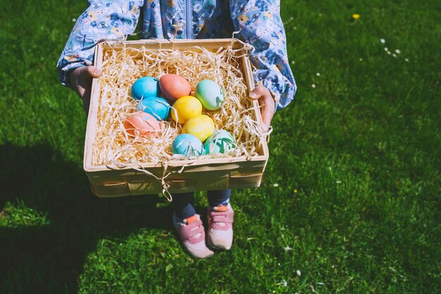 Uova di pasqua colorate nel cesto i bambini cacciano le uova all'aperto