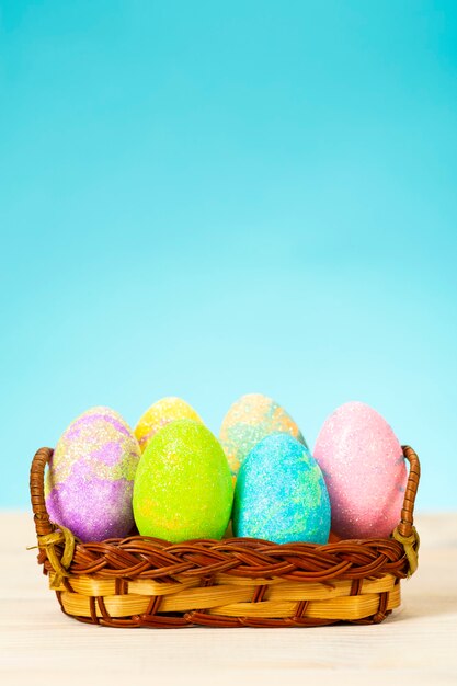 Foto uova di pasqua colorate nel carrello sul tavolo sulla superficie blu