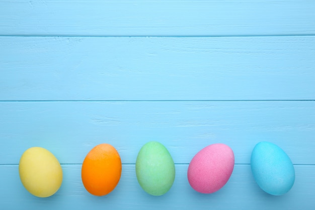 Uova di pasqua colorate su uno sfondo di legno blu