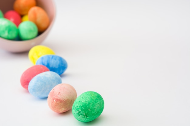 Colorful easter eggs in a bowl isolated on white background copy space