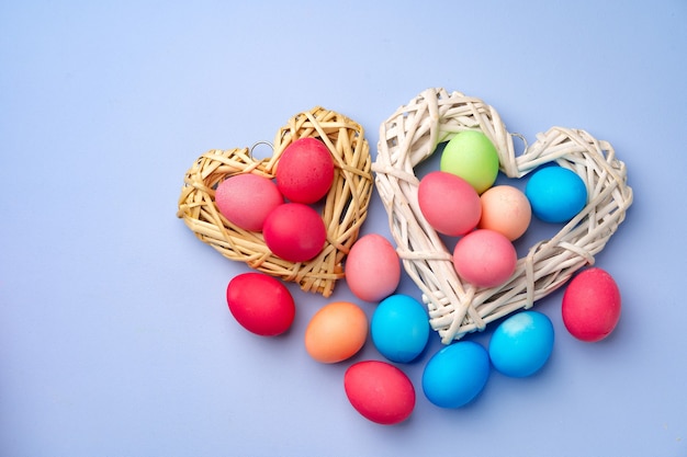 Colorful Easter eggs in decorative nest on blue