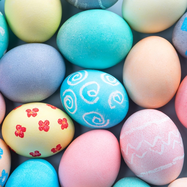 Colorful Easter eggs dyed by colored water with beautiful pattern on a pale blue background design concept of holiday activity top view full frame