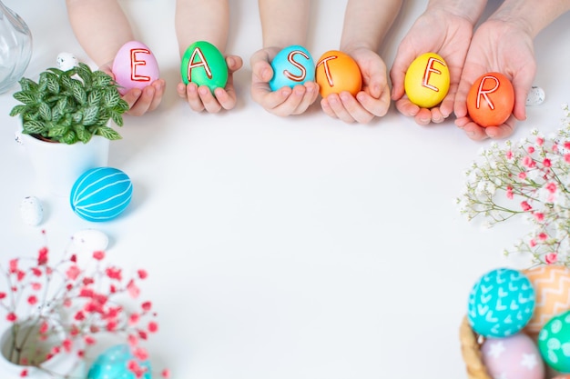 Фото Красочные пасхальные яйца в руках с текстовой праздничной плоской планировкой с копировальным пространством
