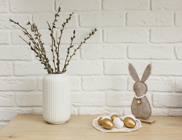 Photo colorful easter eggs on a light background easter bunny willow branches in a vase