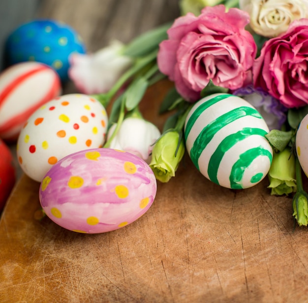 Colorful easter eggs and lisianthus on wooden table