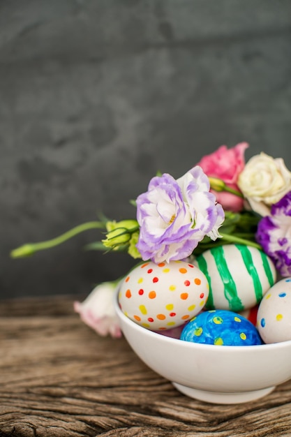 Colorful easter eggs and lisianthus on wooden table