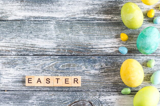 colorful easter eggs on shabby blue wooden background and "easter" letters