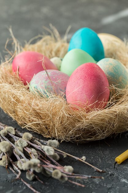 Colorful easter eggs in straw nest on a table