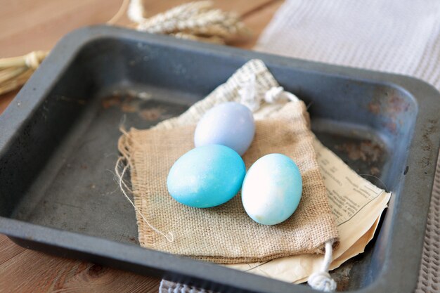 집에서 핸드페인팅을 위한 웃는 이모티콘이 있는 다채로운 부활절 달걀. 갈색 계란 얼굴이 종이 배경에 함께 배열되어 있고, Eeg에 선택적 초점이 있습니다. 많은 다채로운 유기농 닭고기 신선한 계란