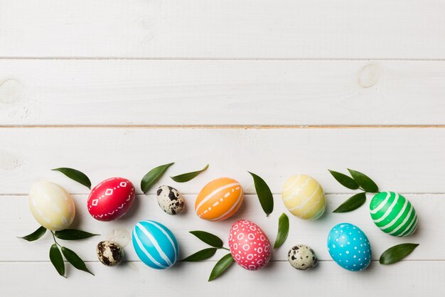 Colorful Easter eggs with spring flower leaf isolated over white background Colored Egg Holiday border