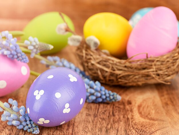 Colorful Easter eggs with spring flowers on wooden background