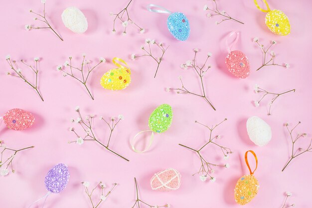 Colorful easter eggs with white gypsophila on pink background