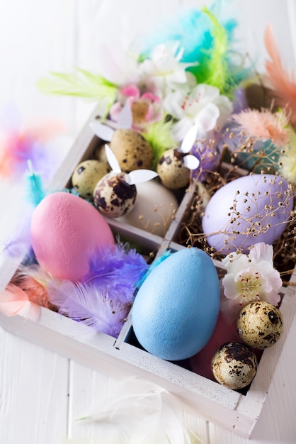 Colorful easter eggs in wooden box on white