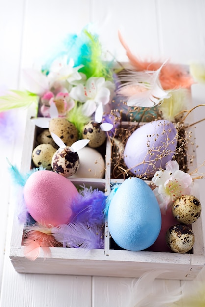 Colorful easter eggs in wooden box on white