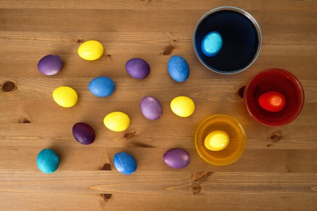 Foto uova di pasqua colorate su un tavolo di legno vista dall'alto