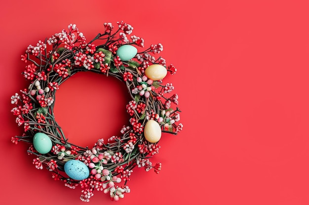 Colorful easter wreath with vibrant eggs on red background festive spring holiday decoration