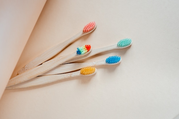 Colorful eco friendly bamboo toothbrushes on light pastel background, dental care with zero waste concept, sustainable lifestyle