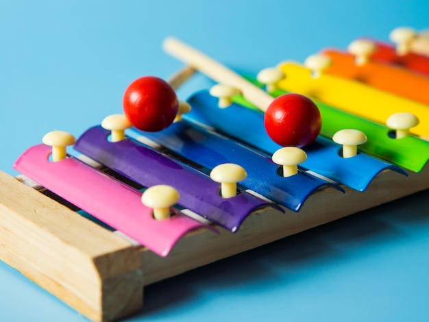 Colorful educational xylophone toy on a blue background with copy space. Children's toy and musical instrument.