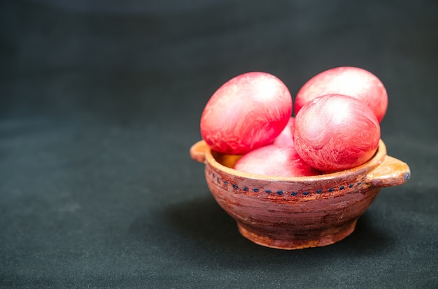 Colorful eggs in clay bowl