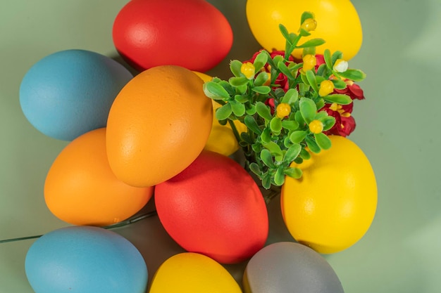 Colorful eggs symbolizing Easter on a colorful background and flowers