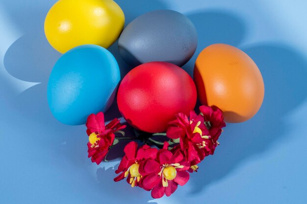 Photo colorful eggs symbolizing easter on a colorful background and flowers