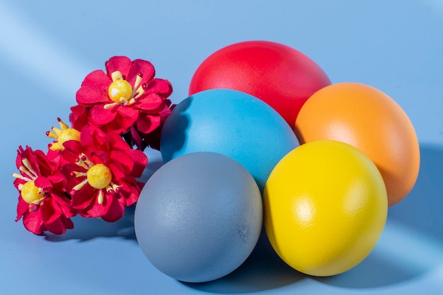 Colorful eggs symbolizing Easter on a colorful background and flowers