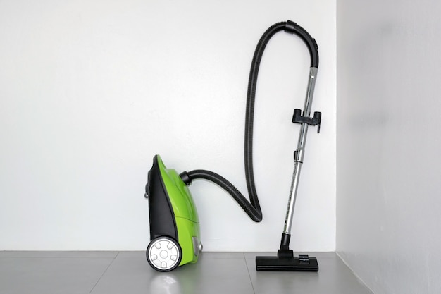 Colorful of electric vacuum cleaner in the white room.