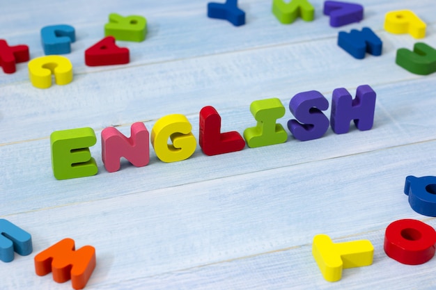 Colorful english word wooden on blue wooden background. 