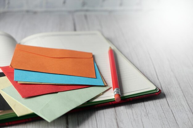 Photo colorful envelope and notepad on wooden table