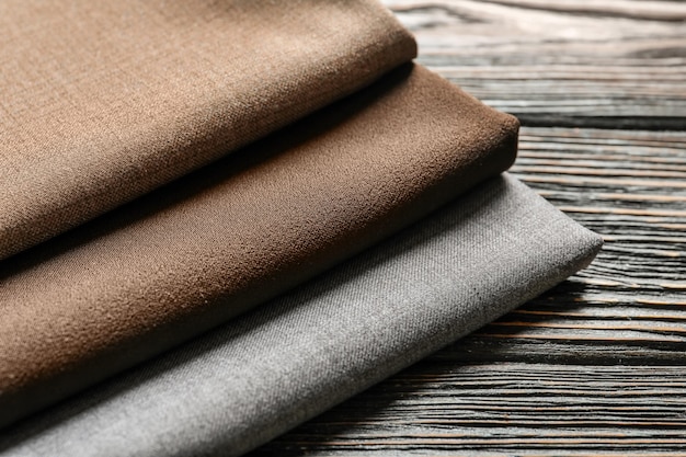 Colorful fabrics on wooden table closeup